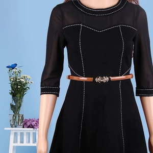 Schwarzes Kleid mit weißen Kontrastnähten und braunem Gürtel mit Rosenschnalle am Model