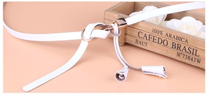 Détail de la ceinture en cuir blanc avec boucle entrelacée en métal doré poli