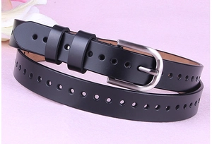 Dettaglio cintura in pelle nera con fibbia argentata opaca e design con fori rotondi
