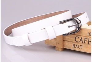 Nahaufnahme weißer Ledergürtel mit dunkler Hufeisenschnalle auf Vintage-Holzkiste