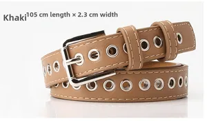 Detail view of khaki leather belt with silver buckle and round metal eyelets