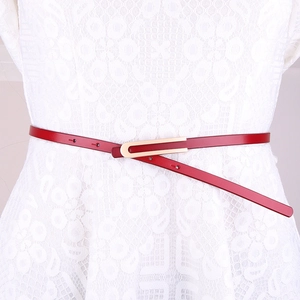 Ceinture minimaliste en cuir rouge avec boucle dorée en U sur robe en dentelle