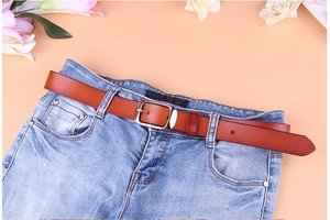 Cintura classica in pelle marrone con fibbia in metallo argentato su jeans blu