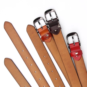 Dettaglio di cinture in pelle marrone e rossa con fibbie ad ardiglione in metallo argento