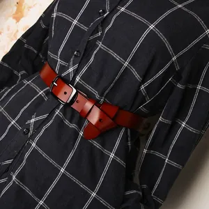 Dettaglio di una cintura da donna in vera pelle marrone scuro con fibbia in metallo nero