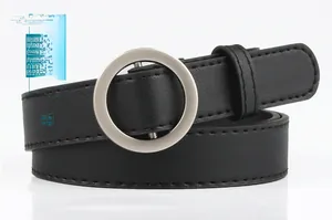 Detail of minimalist black faux leather belt with a polished silver round metal buckle
