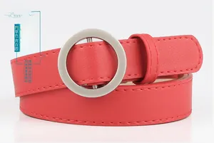 Detail of red slim leather belt with a matte silver circular buckle and stitching