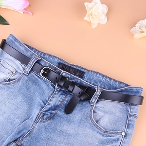 Schmaler schwarzer Ledergürtel für Damen mit Silberschnalle auf hellblauer Jeanshose