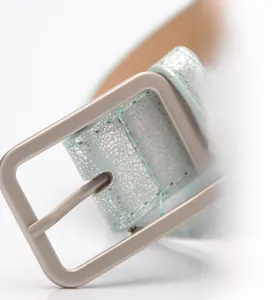 Macro shot of mint green cracked leather belt with matte rectangular alloy buckle