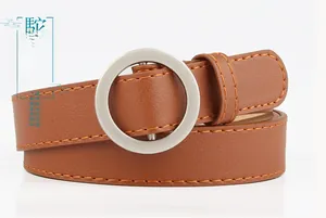 Detail of camel PU leather belt with silver round buckle and yellow contrast stitching