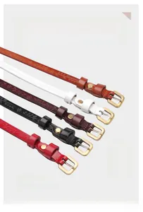 Close-up of slim leather belts for women with floral embossing and vintage gold buckles