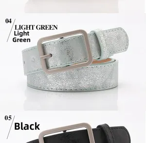 Detail view of light green crackle texture and matte black PU leather belts with gold buckles