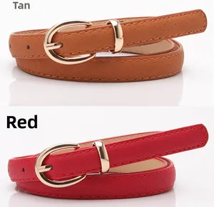 Dettaglio di cinture sottili color cammello e rosso con fibbia dorata e pelle martellata