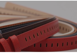 Macro detail of multicolored faux leather belts showing fine stitching and oval cutouts