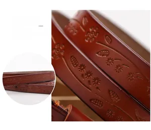 Detail view of embossed floral patterns and smooth oil-edged finish on dark brown leather belt