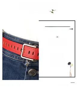 Detail of red leather belt with silver square buckle worn on dark blue denim jeans