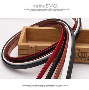 Close-up of five colorful genuine leather slim belts displayed on a vintage wooden box