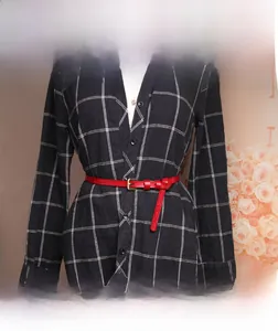 Detail of red leather thin belt with embossed pattern and vintage buckle on a dress