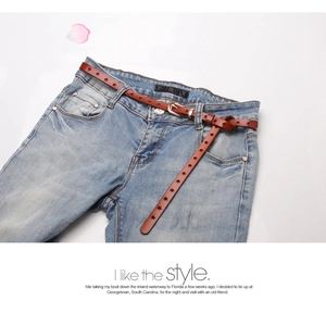 Close-up of brown star cut-out leather belt with gold buckle on denim jeans
