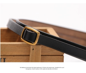 Detail of slim black leather belt featuring a vintage brushed gold square buckle