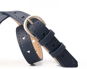 Dettaglio della cintura blu navy con ritagli a cuore e fibbia in metallo spazzolato