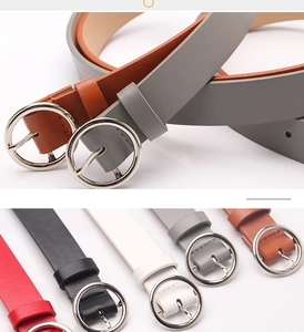 Detail of round silver buckles on leather belts in red, black, white, gray, and brown
