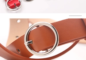 Detailed close-up of round silver metal buckles on red and caramel thin leather belts