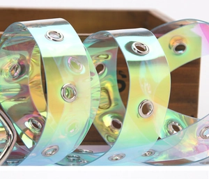 Nahaufnahme des holografischen PVC-Gürtels mit silbernen Metallösen auf einer Holzkiste