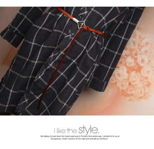 Close-up of a brown leather belt tied over a navy blue checkered long sleeve dress shirt