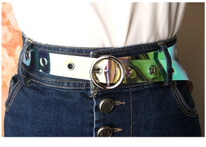 Detail eines holografischen PVC-Gürtels für Damen mit Rundschnalle und Ösen auf Jeans