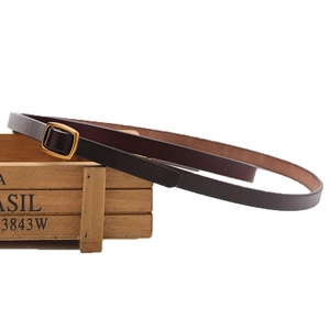 Minimalist dark brown leather skinny belt with golden square buckle on wood decor