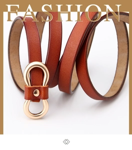 Detailed macro view of retro brown leather thin belt with elegant gold double-ring buckle