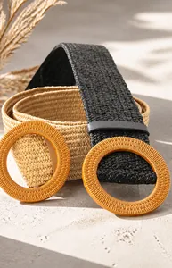 Detalle de cinturones bohemios trenzados en negro y caqui con hebilla redonda de madera