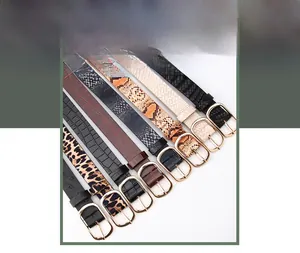 Detail of thin women belts with leopard snake patterns and golden oval buckles