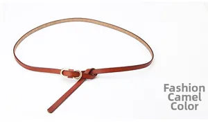 Detail view of camel leather belt featuring a golden double-ring buckle and knotted design
