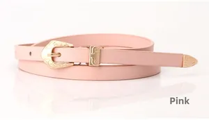 Detail of light pink leather belt featuring a vintage golden engraved buckle and metal tip
