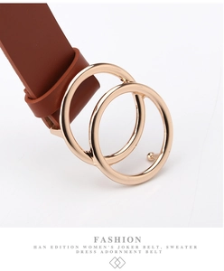 Detailed close-up of golden double-ring buckle on premium brown leather fashion belt