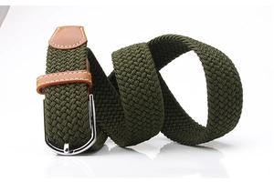 Détail d'une ceinture tressée élastique vert armée avec finitions en cuir brun et boucle