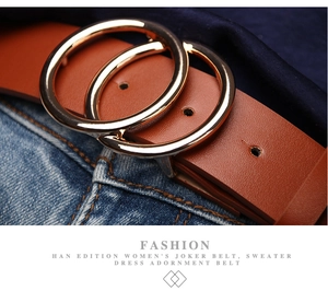 Macro detail of brown leather belt with gold double ring buckle on denim jeans