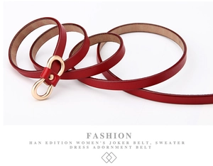 Detail of red slim leather belt with gold infinity buckle for dresses and sweaters