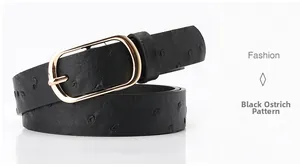Detail of black ostrich embossed leather belt featuring a polished gold oval pin buckle
