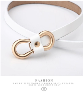 Close-up of white leather skinny belt featuring a matte gold rounded horseshoe metal buckle