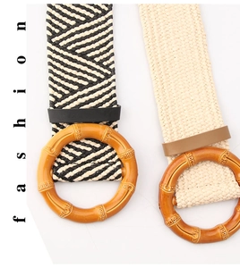 Detail of woven elastic waist belts with bohemian style round wood buckle and straw texture