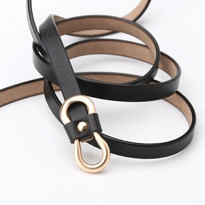 Minimalist black leather skinny belt for women with a gold horseshoe buckle on white background