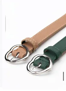 Close-up of slim fashion belts with silver heart buckles in brown and dark green colors