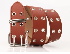 Détail d'une ceinture marron en similicuir avec double rangée d'œillets argentés et boucle