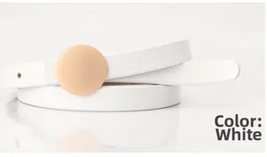 Detail view of a white leather waist belt featuring a round matte gold metal pin buckle