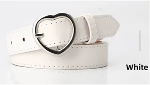 Detailed view of white faux leather belt with a silver heart-shaped metal buckle and stitching