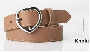 Detailed view of khaki faux leather belt with heart-shaped buckle and white stitching