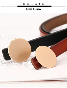 Close-up of a stylish gold round metal buckle on a minimalist slim leather waist belt
